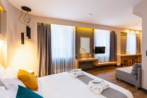 Une chambre d’hôtel moderne, dotée d’un grand lit, d’un canapé, d’un bureau et d’une télévision.