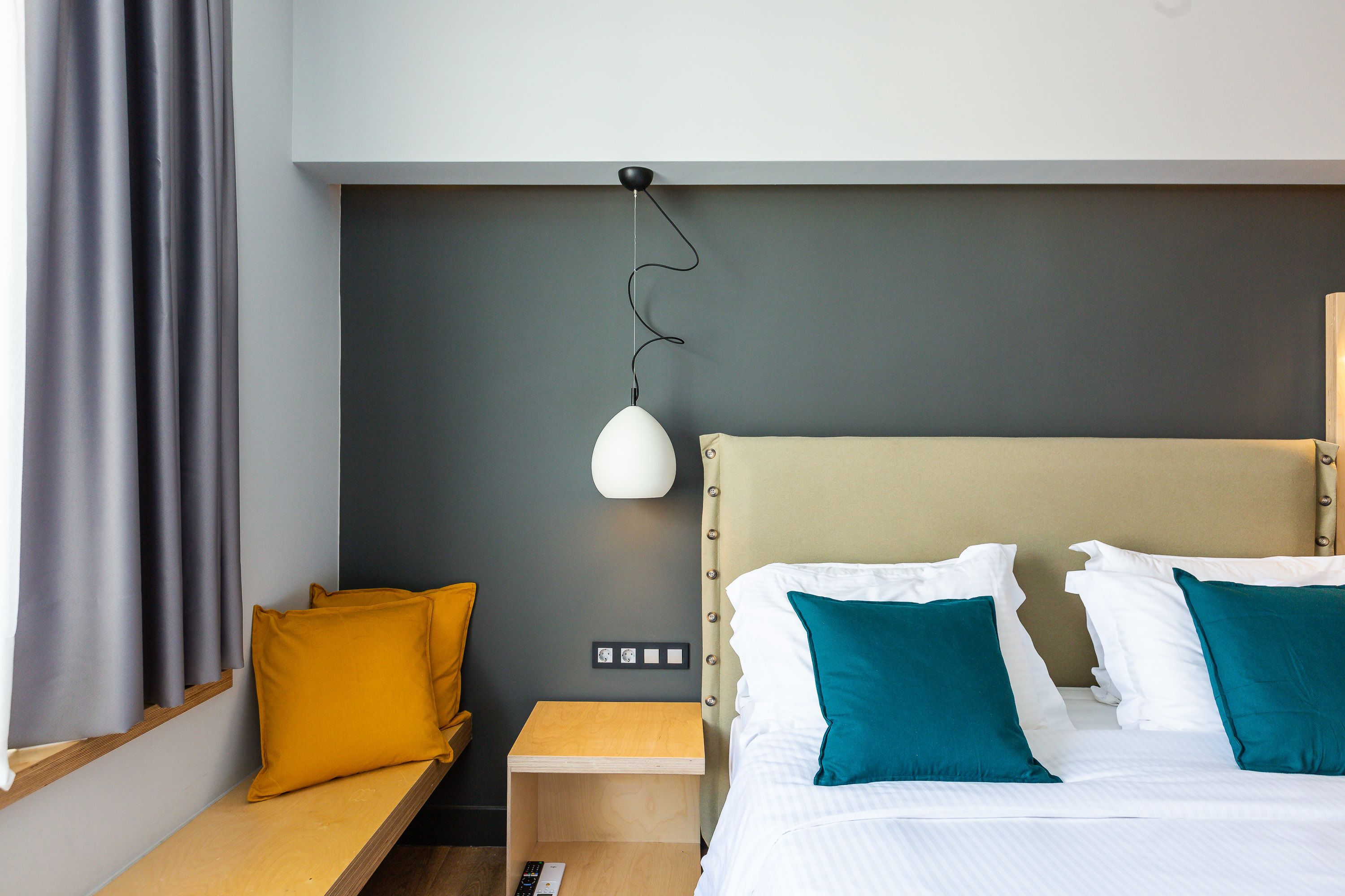 Une chambre d’hôtel avec un lit, une table de chevet et une lampe.