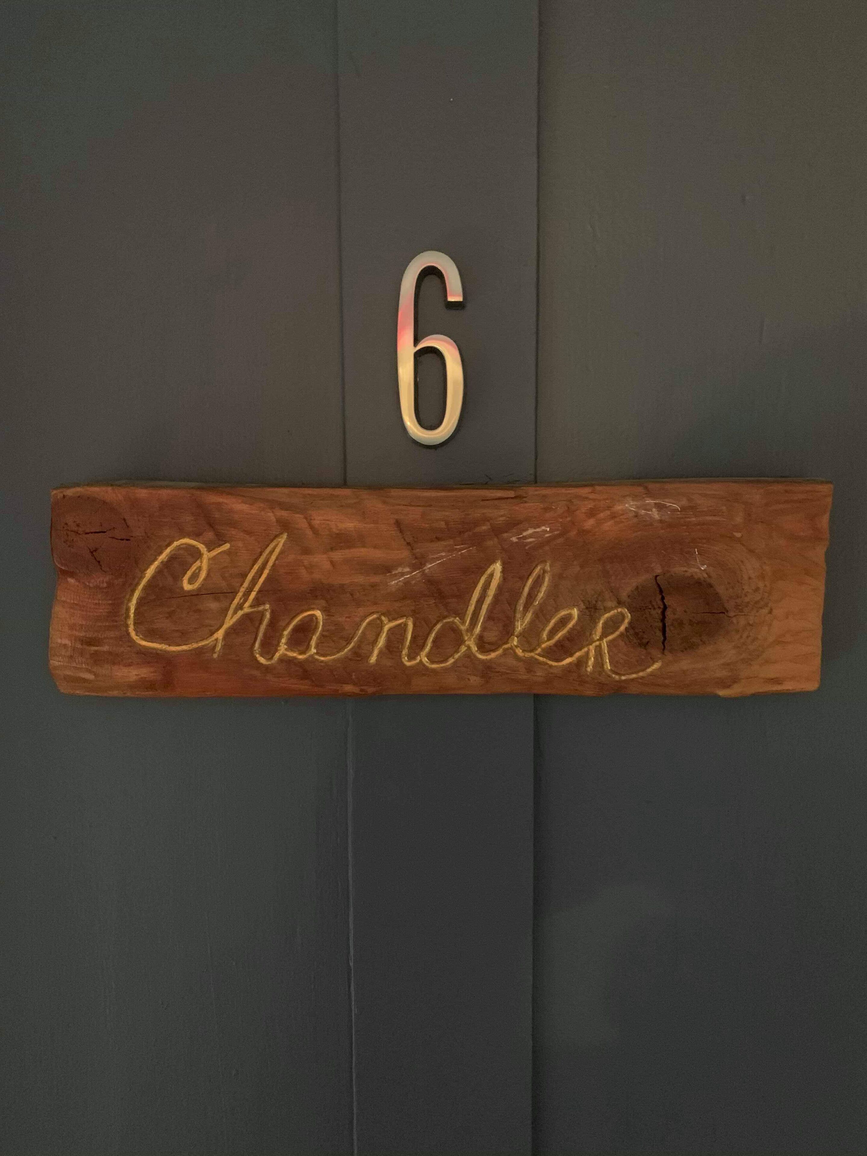 Ein Holzschild mit der Nummer 6 und dem Namen 'Chandler'.