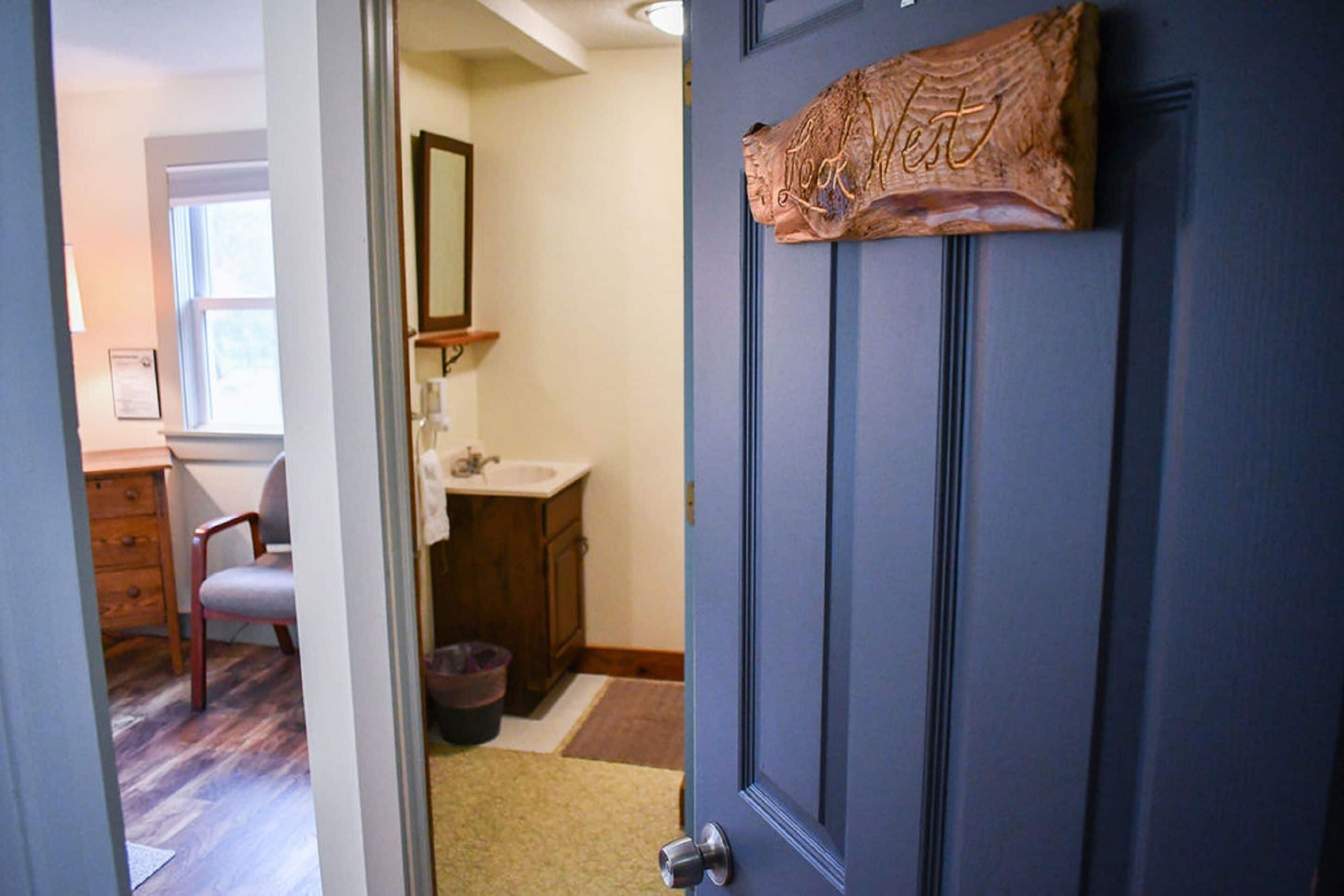 A bathroom with a sink, mirror, and wooden cabinet.
