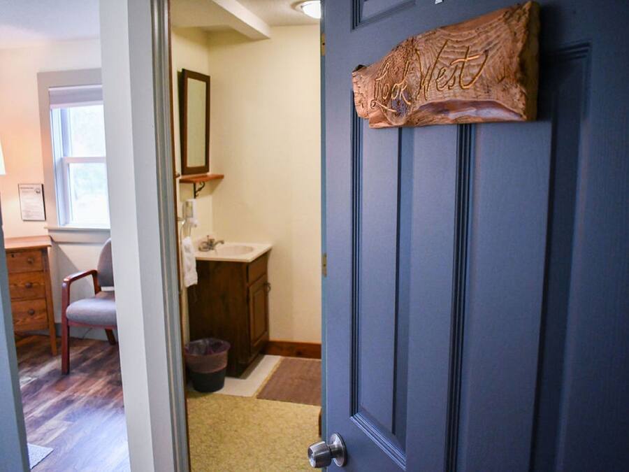 A bathroom with a sink, mirror, and wooden cabinet.