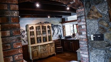 Una cocina rústica con armarios de madera, una pared de piedra y un mural de una montaña.