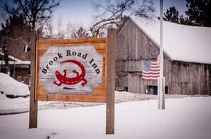 A wooden sign with "Brook Road Inn" and a red dragon logo.