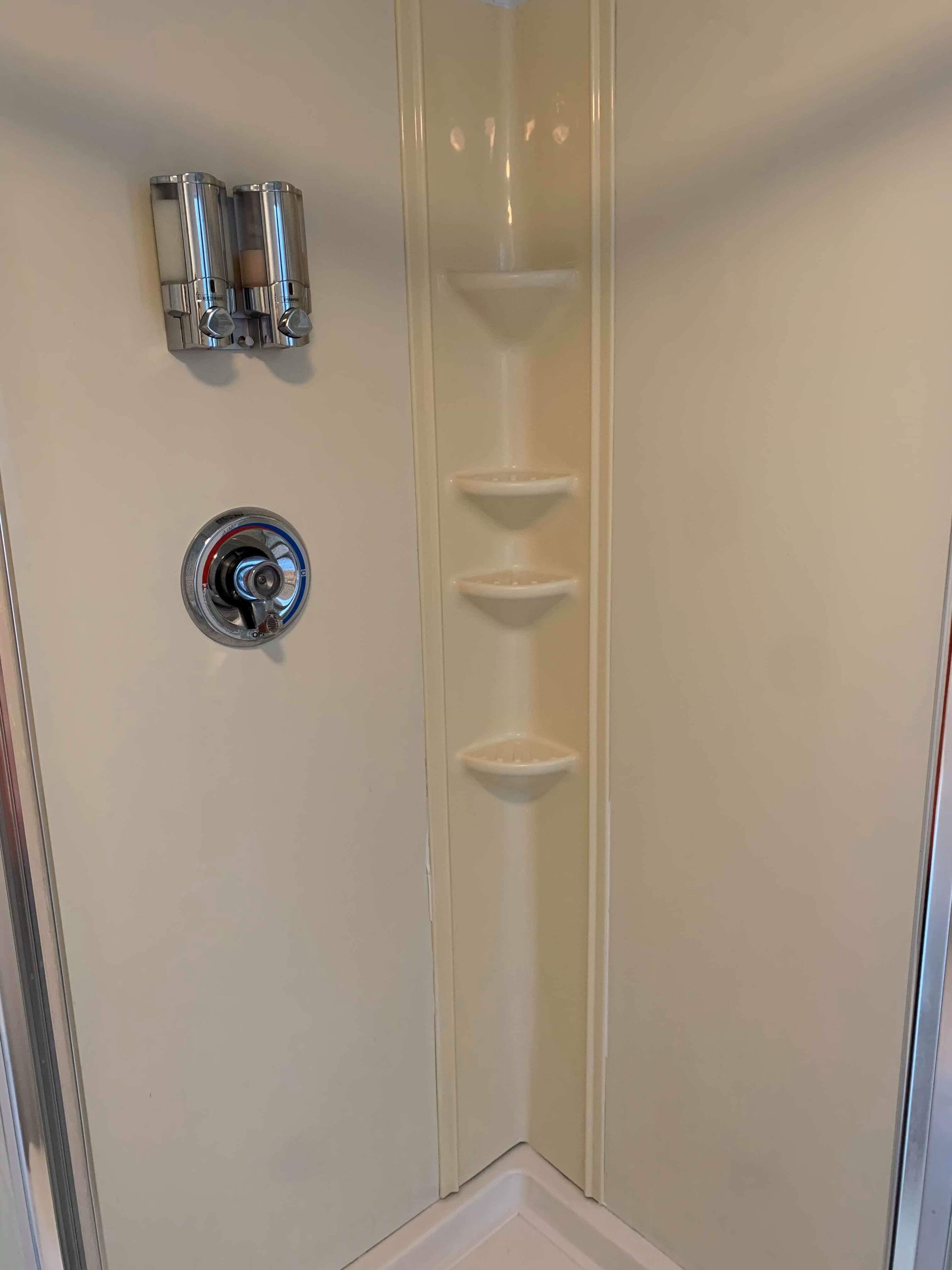 A corner of a room with a white wall, a corner shelf, and a flush mount light fixture.