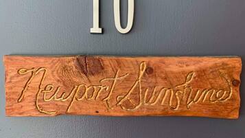 A wooden sign with the number 10 and the words "Newport Sunshine" carved into it.