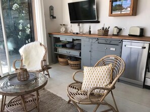 A kitchen with a dining area, a television, and a view of the outdoors. - Le Nid du Héron: An urban vacation rental with a heated pool in the heart of Nantes (Nantes)