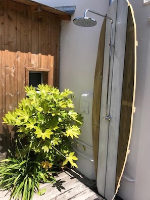 A wooden deck with a glass-enclosed shower area and a potted plant. - Le Nid du Héron: An urban vacation rental with a heated pool in the heart of Nantes (Nantes)