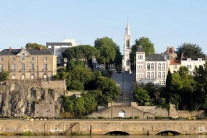 Uma cidade histórica com uma torre de igreja imponente, uma ponte e arquitetura clássica.