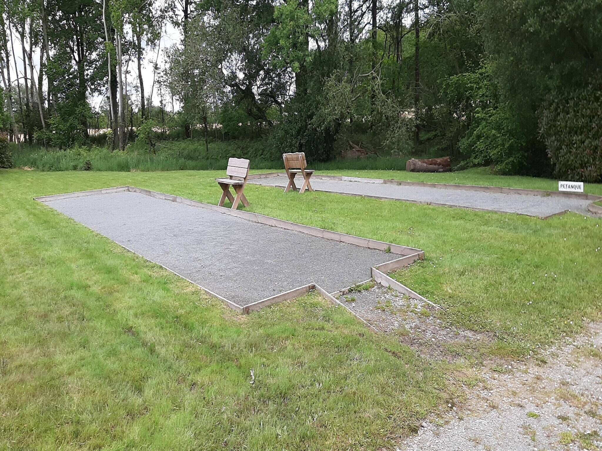 A grassy area with two wooden benches and a paved path.