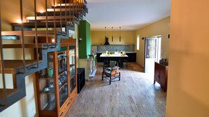 A spacious kitchen with a dining area, a staircase, and a view of the outside. - La Riggiola (Salerno)