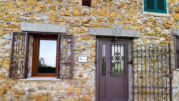 A stone building with a brown door and window shutters. - La Riggiola (Salerno)