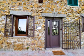 A stone building with a brown door and window shutters. - La Riggiola (Salerno)