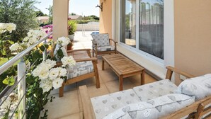 A balcony with wooden furniture, including a sofa and chairs, and a table. - Lovely home in Saint-Gilles (Saint-Gilles)