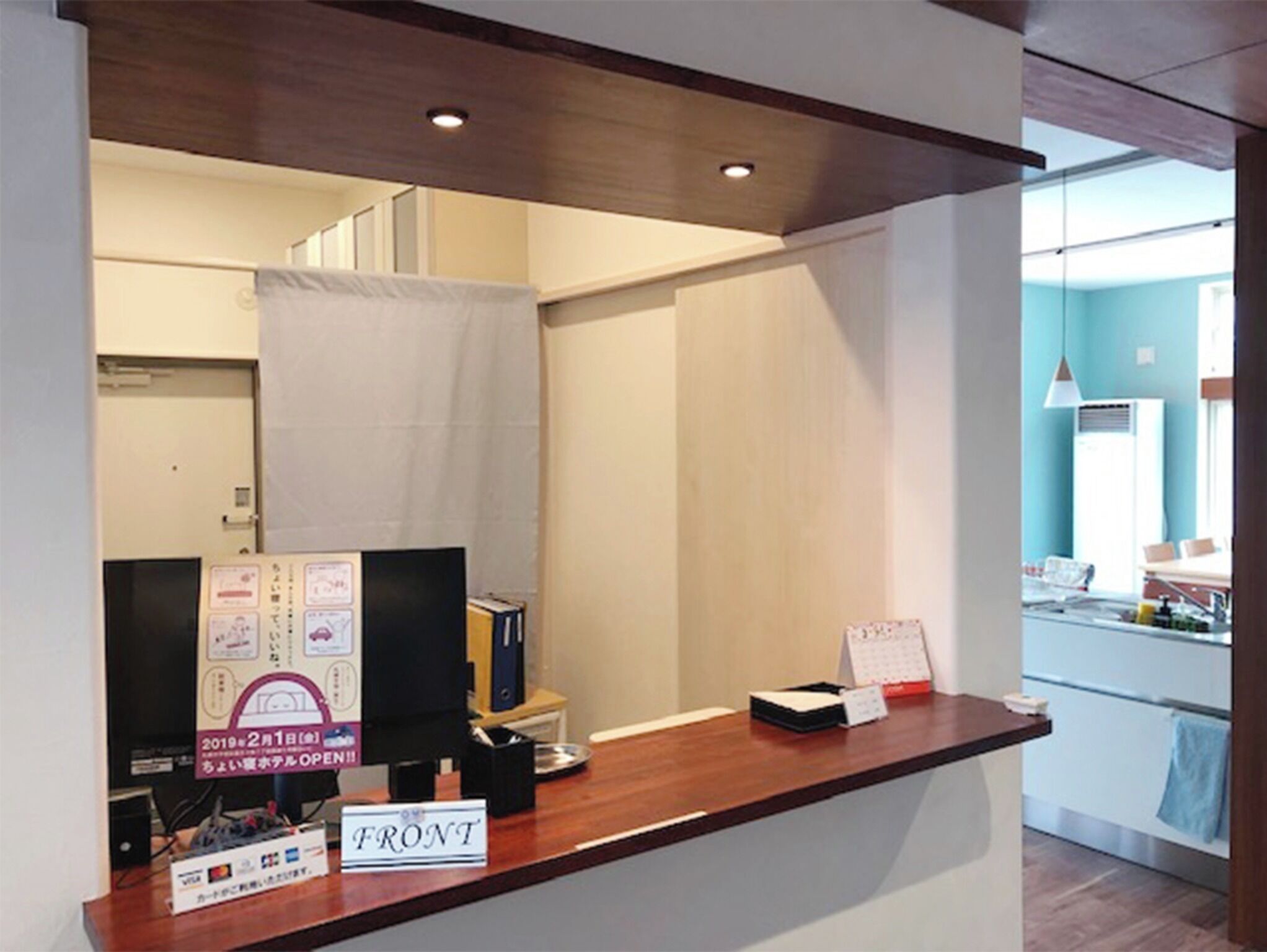A reception desk with a sign reading 'FRONT,' a calendar, and a computer monitor.