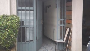 A narrow entrance with a tiled floor, a chair, and a small potted plant.