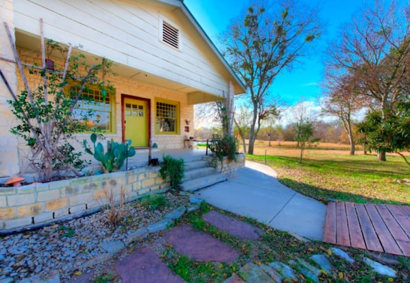 A house with a front porch, a stone retaining wall, and a wooden deck.