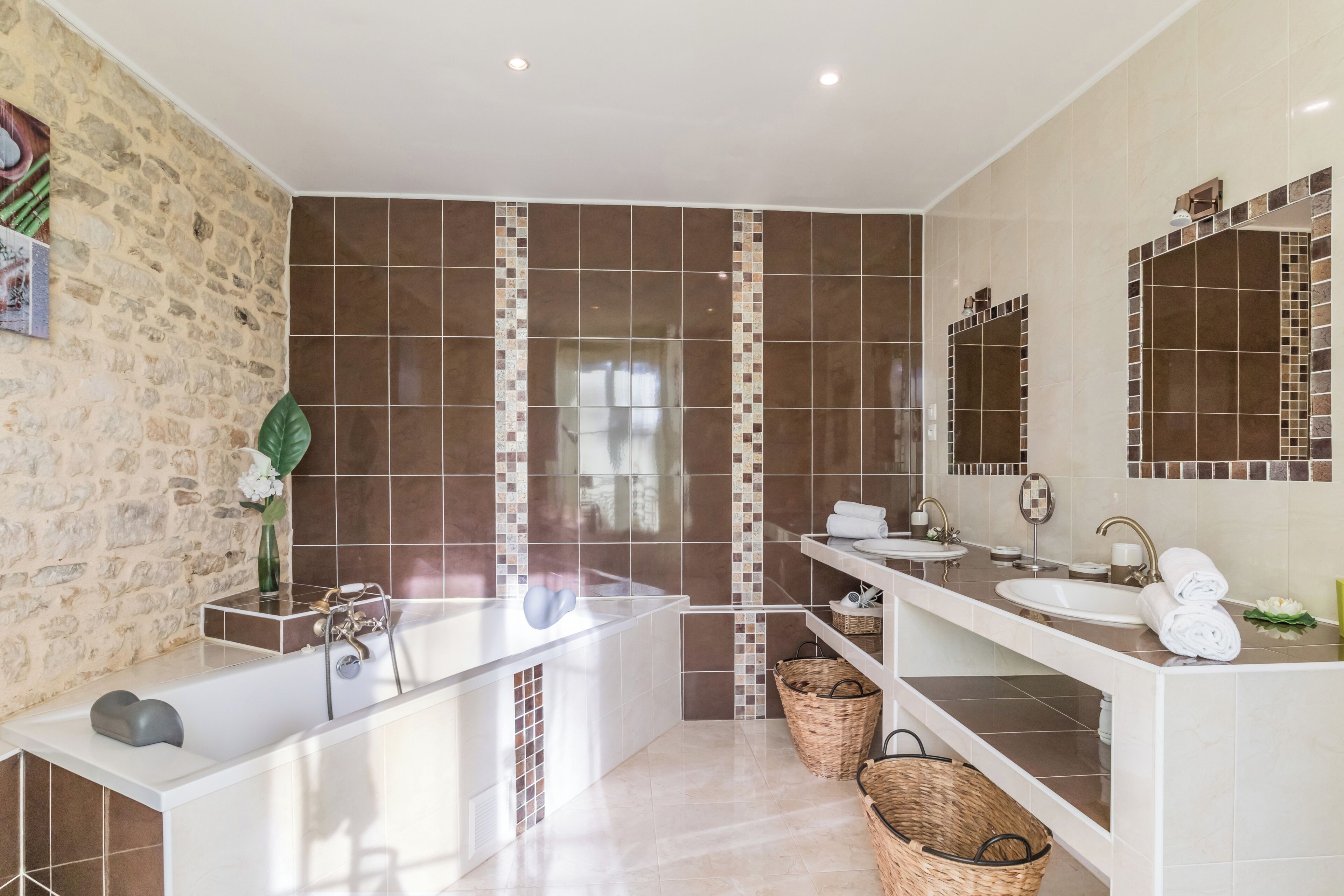 Une salle de bain moderne avec une baignoire, deux lavabos et un grand miroir.