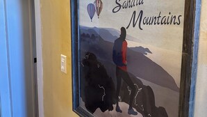Une plaque encadrée portant l’inscription « Visitez Albuquerque et les monts Sandia » et représentant la silhouette d’une personne accompagnée d’un chien.