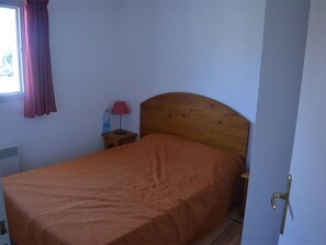 A single bed in a room with a wooden headboard, a small bedside table with a lamp, and a window with curtains. - Duplex for 6 with Terrace, A/C, Heated Pool & Parking in Vallon-Pont-d'Arc (Vallon-Pont-d'Arc)