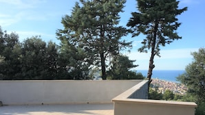 A terrace with a view of the sea and cityscape, surrounded by trees. - Panoramic villa surrounded by greenery with swim.pool and gym 5' from the beach. (Montesecco)
