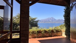 An interior space with a view of a mountainous landscape and a body of water. - Villa Margiò (Torri del Benaco)