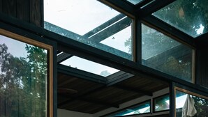 A modern interior with a glass door leading to a wooden deck. - Finca Victoria (Vieques)