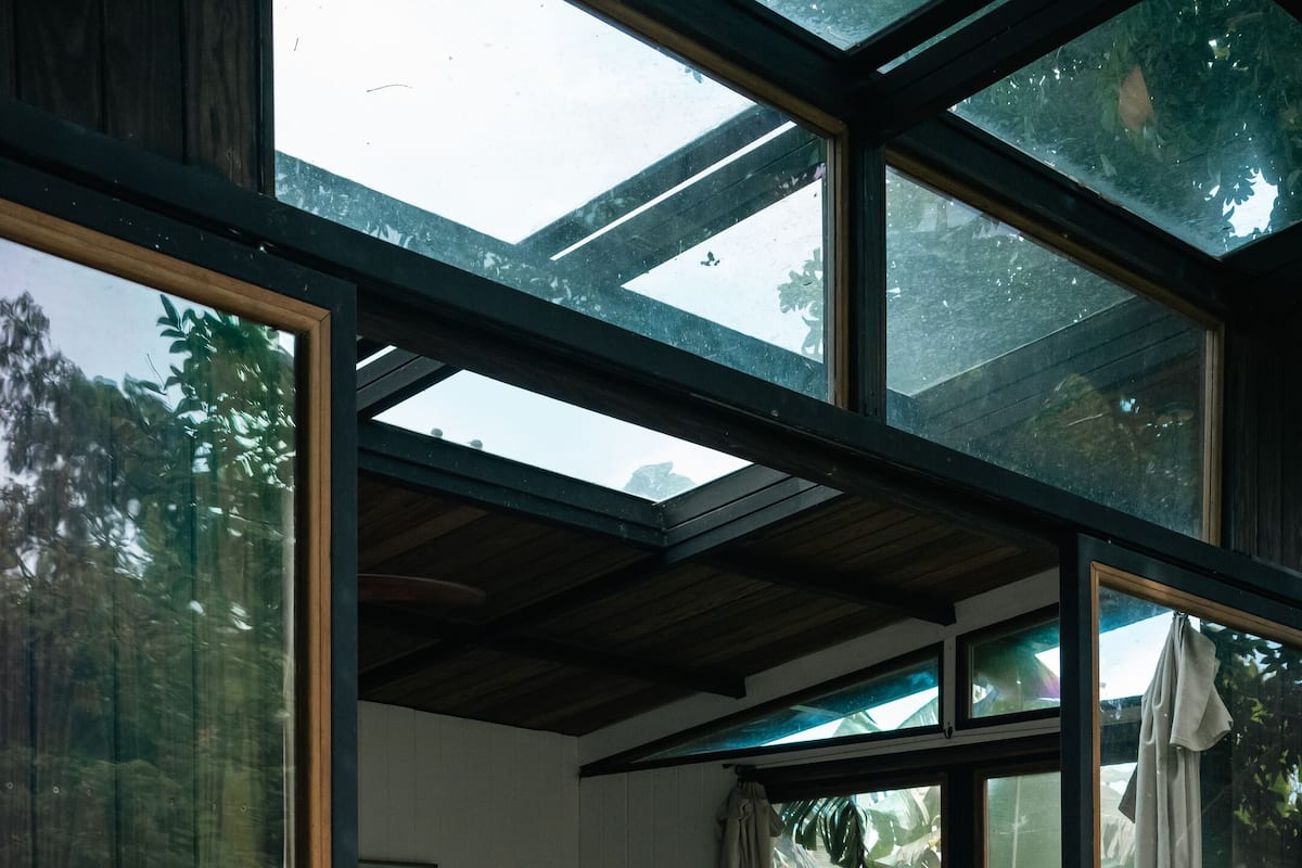 A modern interior with a glass door leading to a wooden deck.