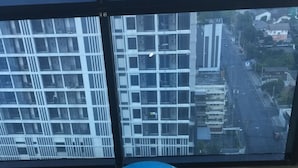 Un ballon d’exercice bleu dans une pièce dotée de grandes fenêtres donnant sur un paysage urbain.