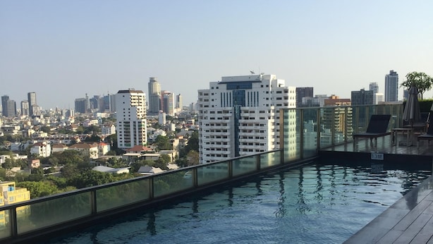 Une piscine sur le toit, offrant une vue sur la ville et entourée d’immeubles.