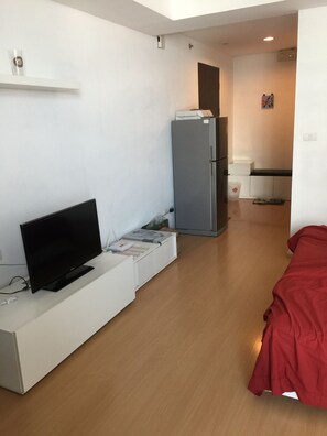 Cozy living space with a flat-screen TV, kitchenette, and a comfortable bed.