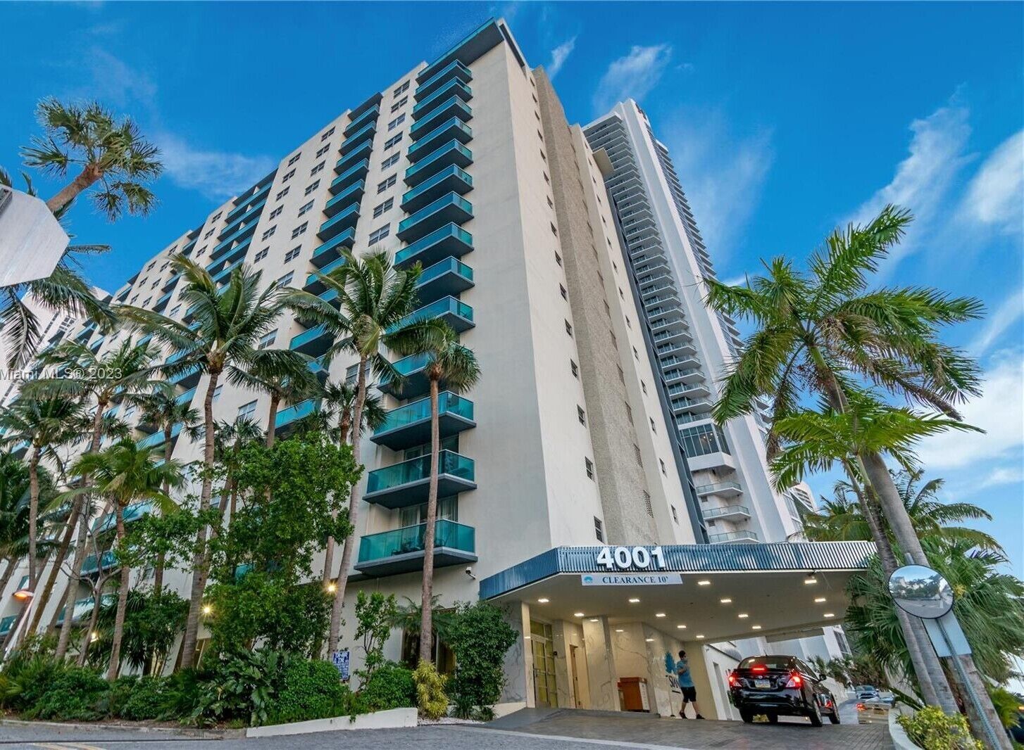 A high-rise hotel with a modern design, featuring a prominent entrance with a sign reading "4001 CLEARANCE 10'".