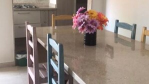 Ein Essbereich mit Tisch, Stühlen und einem Blumenstrauß.