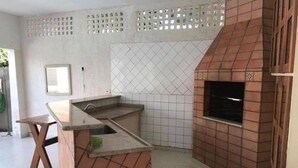 Eine Küche mit gefliestem Rücksprung, einem eingebauten Backofen und einer hölzernen Sitzbank.