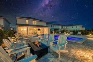 A residential area with a swimming pool, lounge chairs, and a fire pit. - South-Facing Pool Villa with Fire Pit Near Disney (Kissimmee)