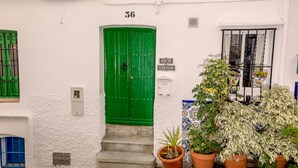 A white building with a green door, a sign reading "Casa Sandia," and potted plants in front. - Casa Sandra, Newly renovated traditional Andalucian townhouse (Competa)