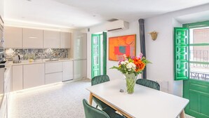 A modern kitchen with white cabinets, a patterned backsplash, and a dining area with a white table and chairs. - Casa Sandra, Newly renovated traditional Andalucian townhouse (Competa)