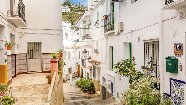 A narrow street with white buildings, a green door, and potted plants. - Casa Sandra, Newly renovated traditional Andalucian townhouse (Competa)
