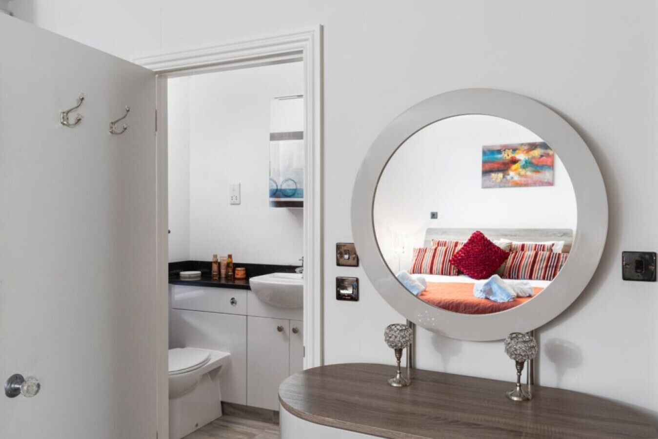 A bathroom with a white sink, a mirror, and a toilet.