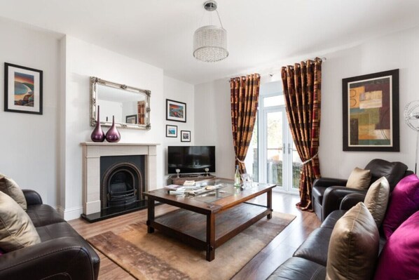 Una sala de estar con chimenea, televisor y una mesa de centro.