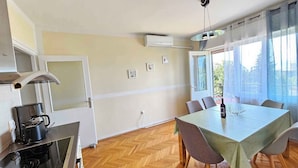 Eine moderne Küche mit Herd, Backofen und Essbereich inklusive Tisch und Stühlen.