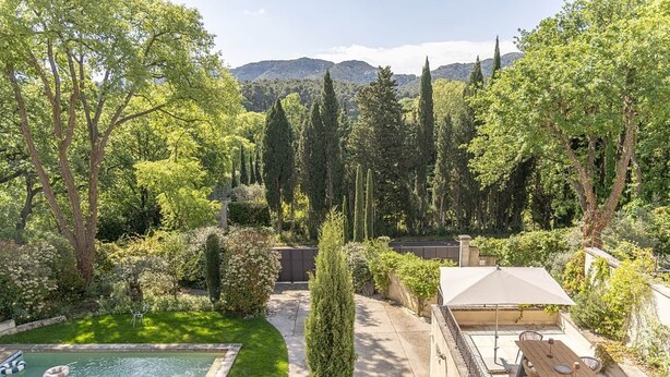 Ein Garten mit Swimmingpool, Grillplatz und Blick auf die Berge.