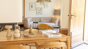 A wooden dining table with chairs, a book titled 'Provence,' and decorative items. - Bastide du Levant du Mas de l'Amarine (ST REMY DE PROVENCE)
