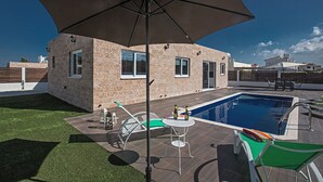 A modern house with a swimming pool, outdoor furniture, and a large umbrella. - Beautiful 5 Star Holiday Villa in a Prime Location in Protaras (Protaras)