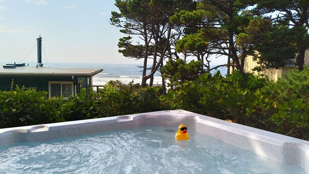 A hot tub with a view of the ocean and a lighthouse in the background. - Nye Beach, Close to everything, Ocean View! (Newport)