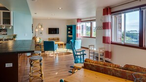 A spacious living area with a kitchen, dining table, and seating. - Nye Beach, Close to everything, Ocean View! (Newport)