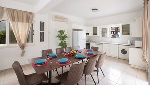 A modern kitchen with white cabinets, a built-in oven, and a washing machine. - How to Rent Your Own Private Luxury Holiday Villa in Protaras for Less than Basic Hotel (Protaras)