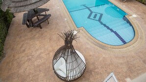 A rectangular swimming pool with a tiled edge, surrounded by lounge chairs and a thatched umbrella. - How to Rent Your Own Private Luxury Holiday Villa in Protaras for Less than Basic Hotel (Protaras)