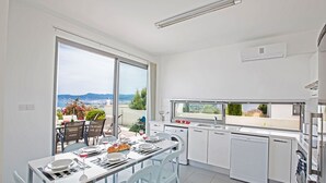 A modern kitchen with a dining area, large windows, and a view of the landscape. - The Complete Guide to Renting Your Exclusive Holiday Villa with Private Pool and Close to the Beach (Paphos)