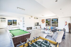 Een televisie, een open haard, videogames en tafelvoetbal