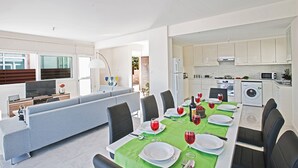Un salon moderne comprenant un coin repas, une cuisine et une buanderie.